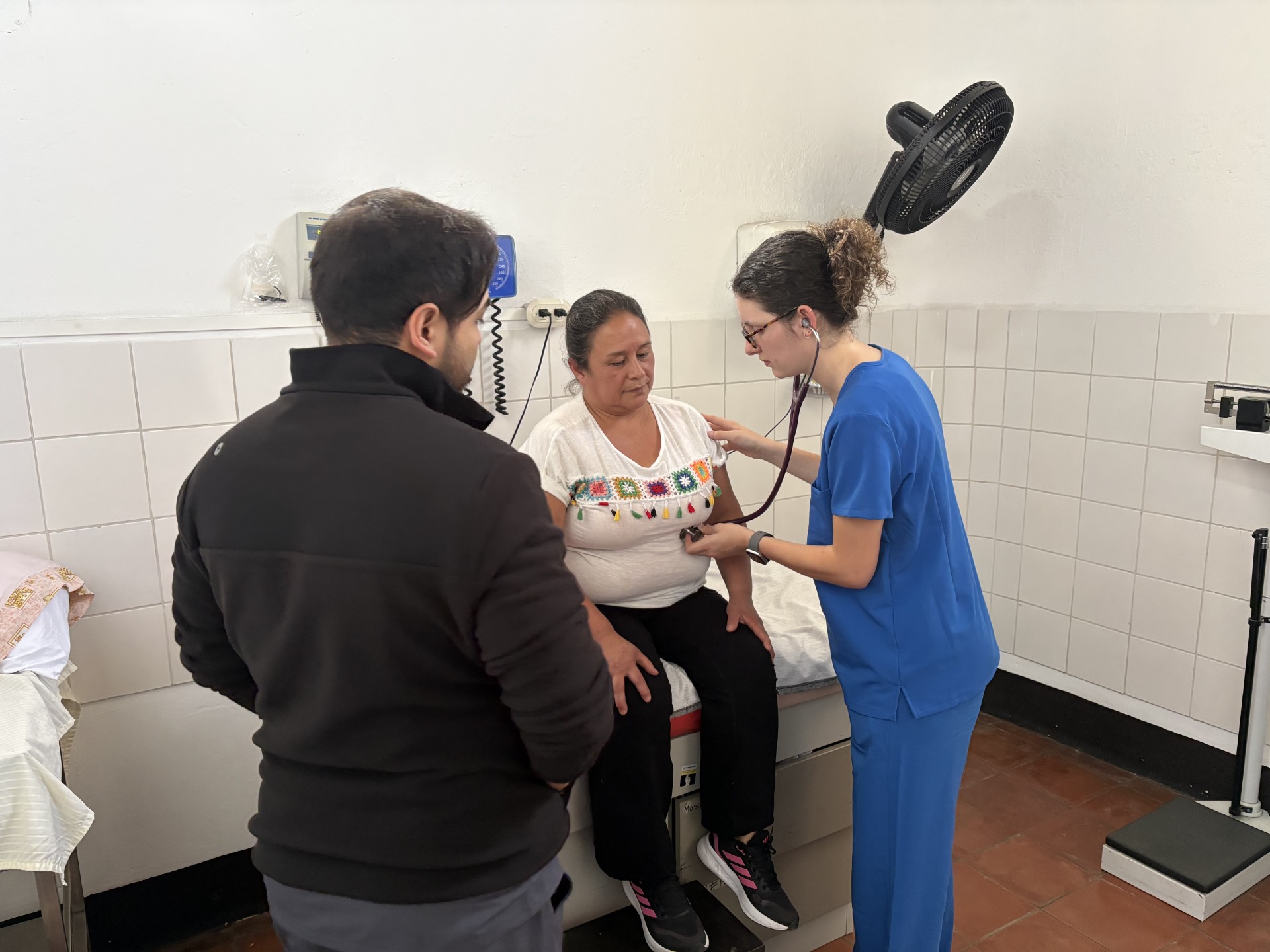 medical student listens to patient's heart
