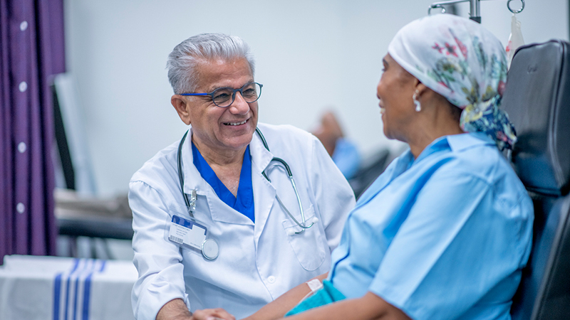 Doctor comforting a cancer patient during treatment in a hospital setting.