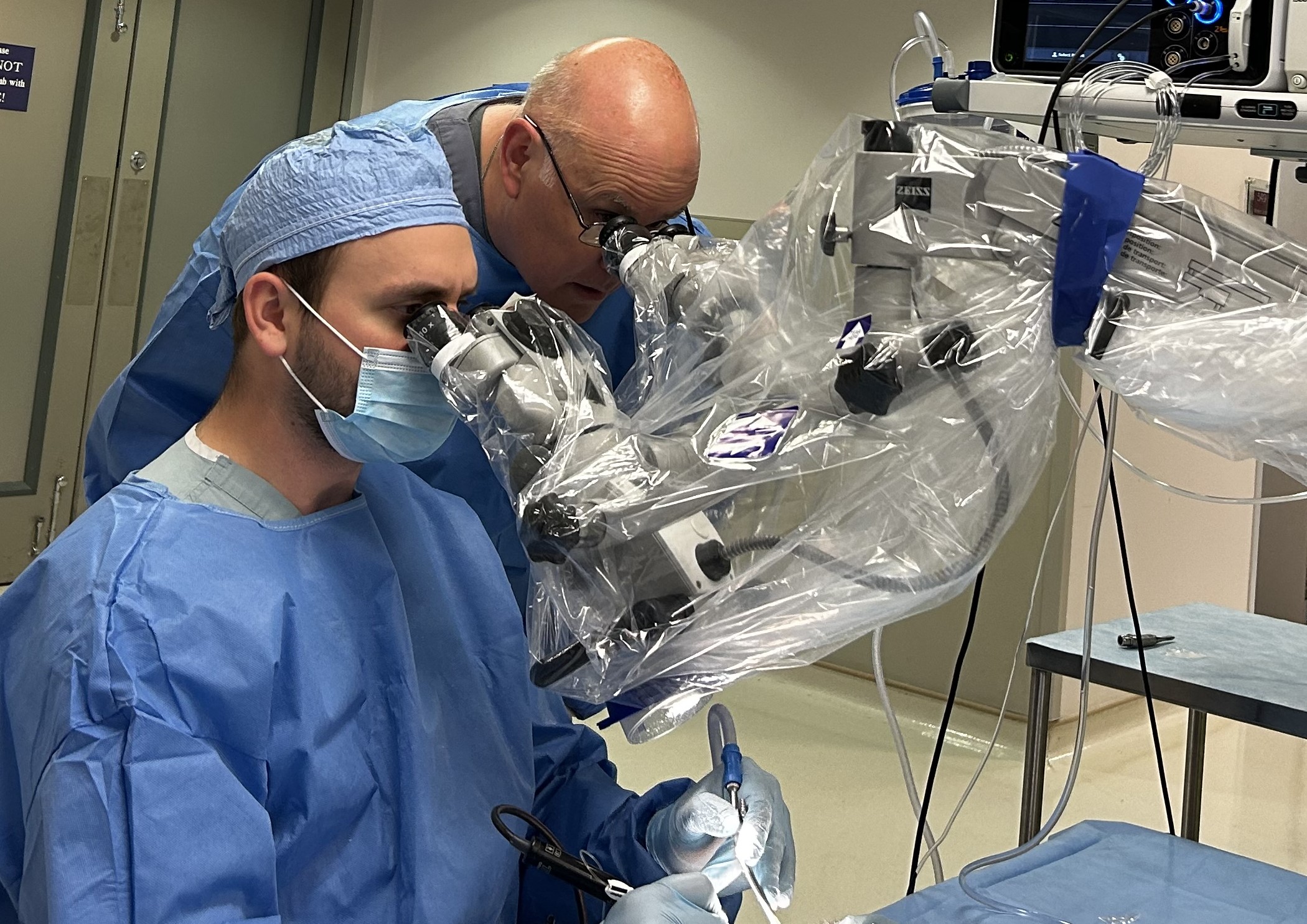 Faculty and resident looking into microscope