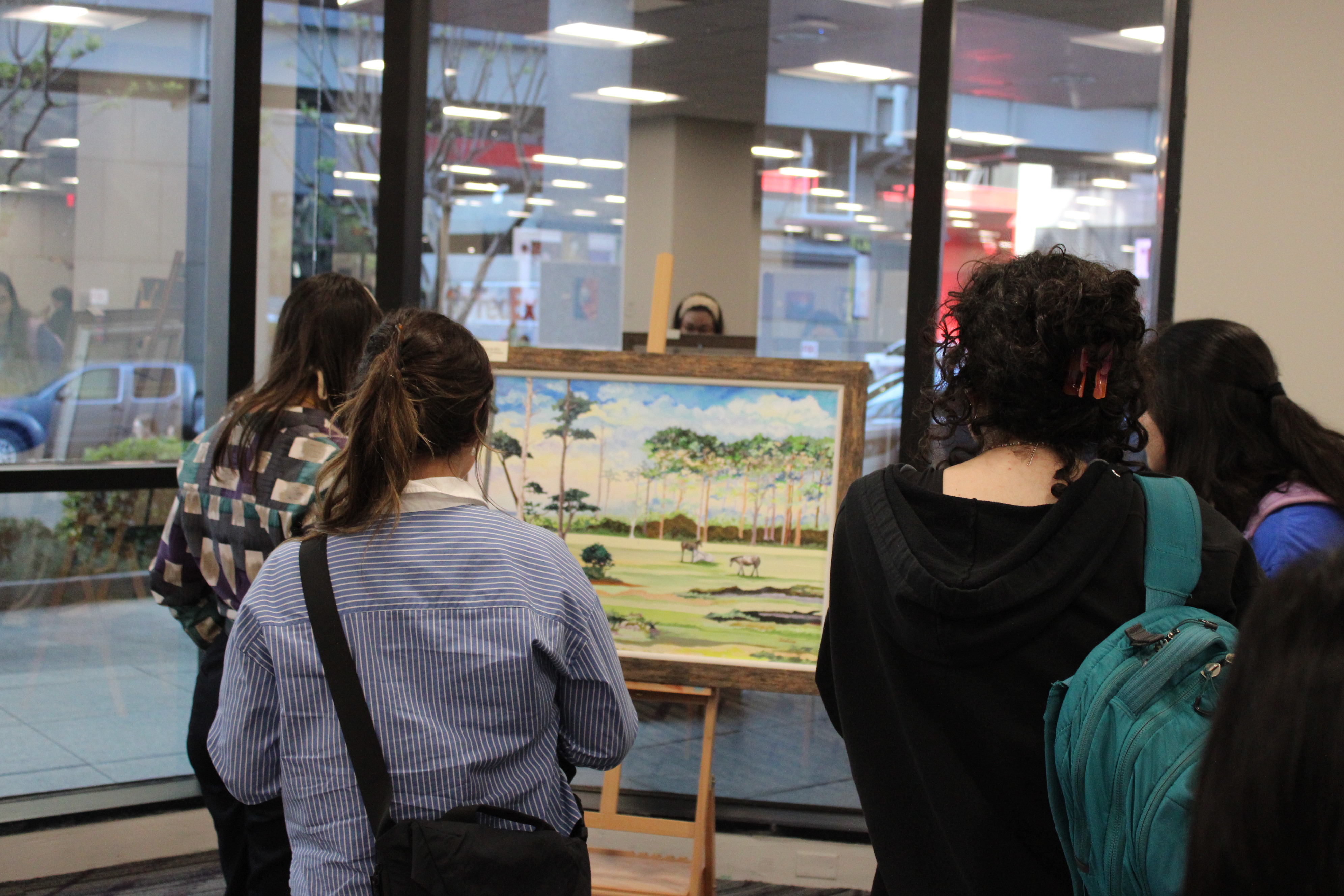 People gather around a painting at the art event